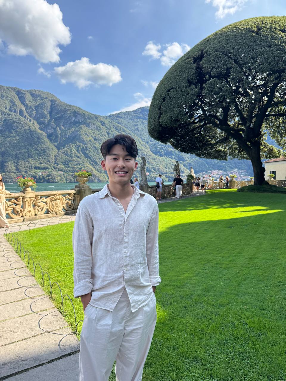 Steven 站在别墅草坪与金色栏杆旁。
