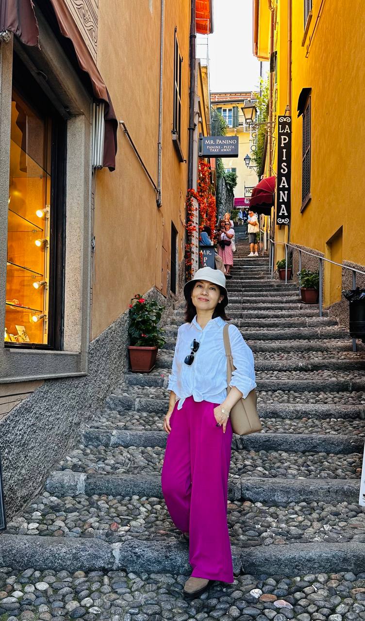 Bellagio 的石阶小巷里，Jing 与两侧的老房子。
