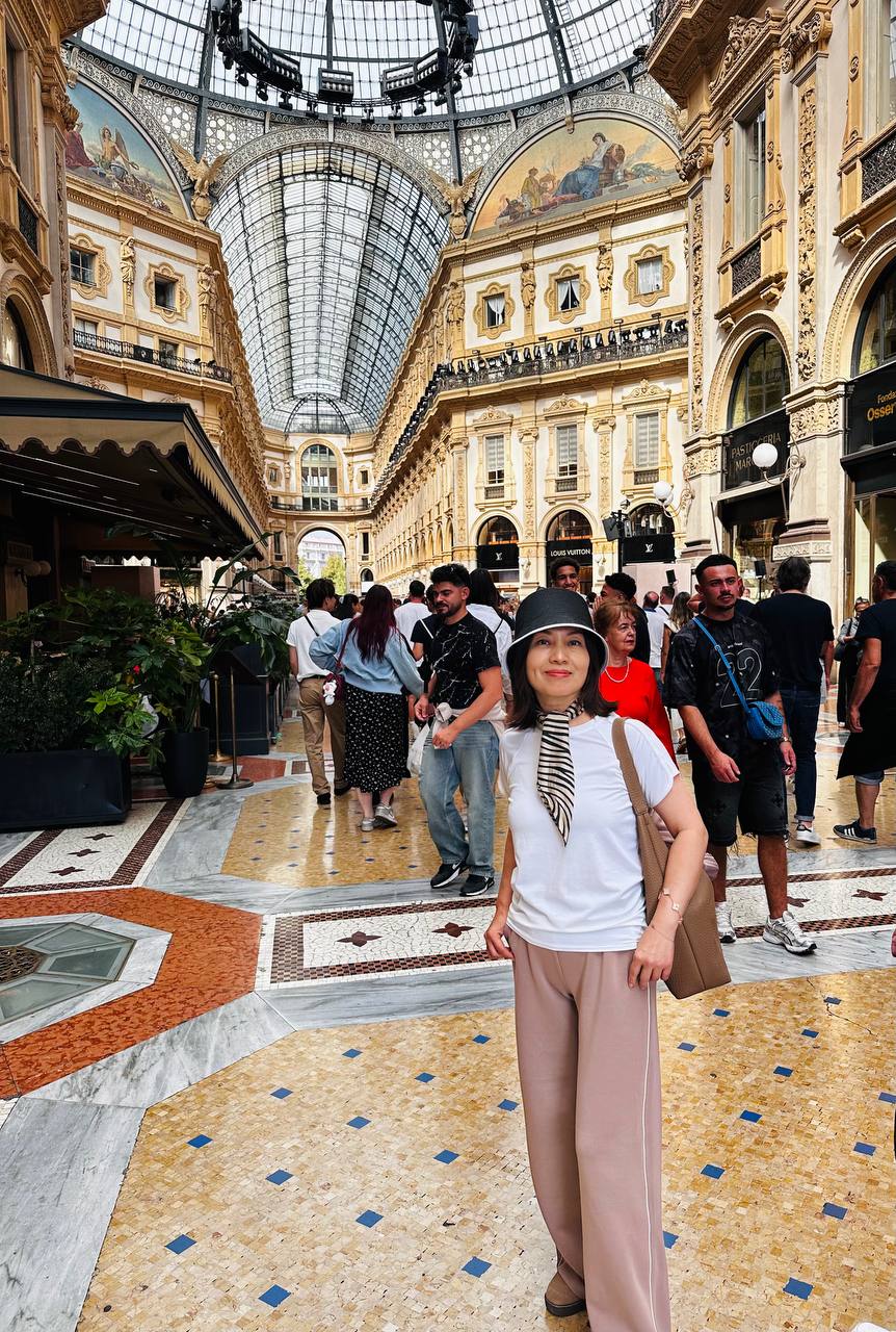 Galleria Vittorio Emanuele II 里，Jing 站在彩色大理石地面上。