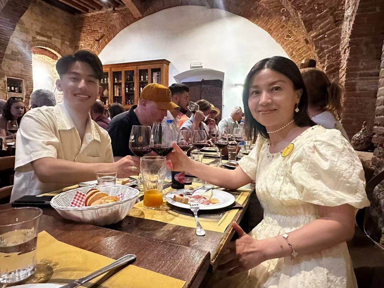 酒窖餐桌上的母子举杯与品酒时光。