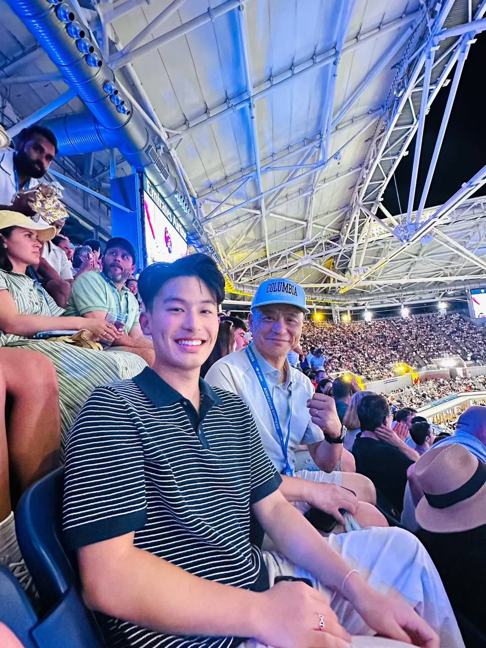 父子在热烈的 Arthur Ashe Stadium 看台上。